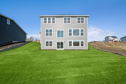 The homeâs back elevation offers large windows that fill the interior with natural light and a walk-out basement ready for future living space. Home under construction, photo of similar home, selections vary.
