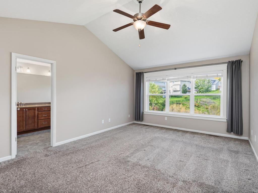 Primary suite with vaulted celing, fan and large window