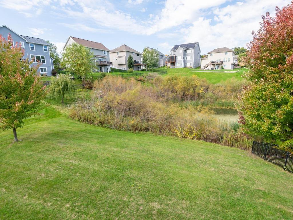 Yard gently sloping to pond, has invisible fencing system.