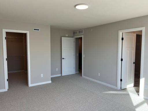 Primary bedroom walk in closet and bathroom with second walk in closet
