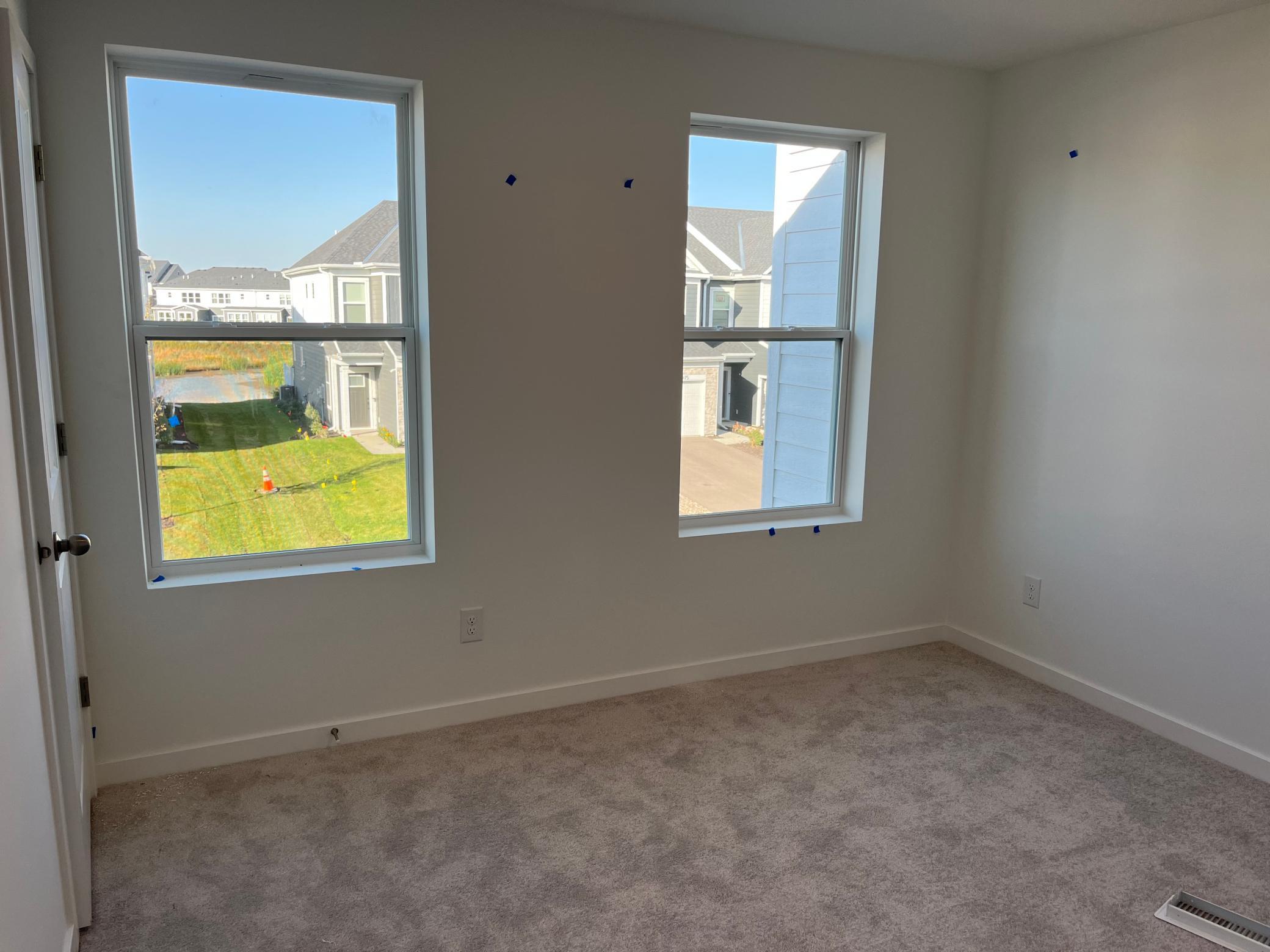 Secondary bedroom with two large windows and walk in closet