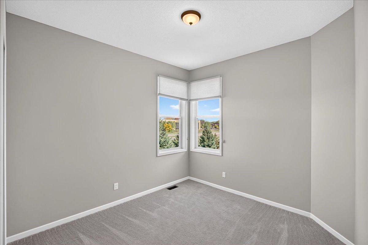 2nd bedroom on Main floor. Bright, versatile space with corner windows, ideal for a guest bedroom, home office, or hobby room.