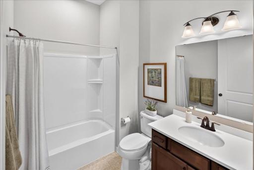 Nicely maintained bathroom with a tub/shower combination, vanity storage, and neutral finishes.