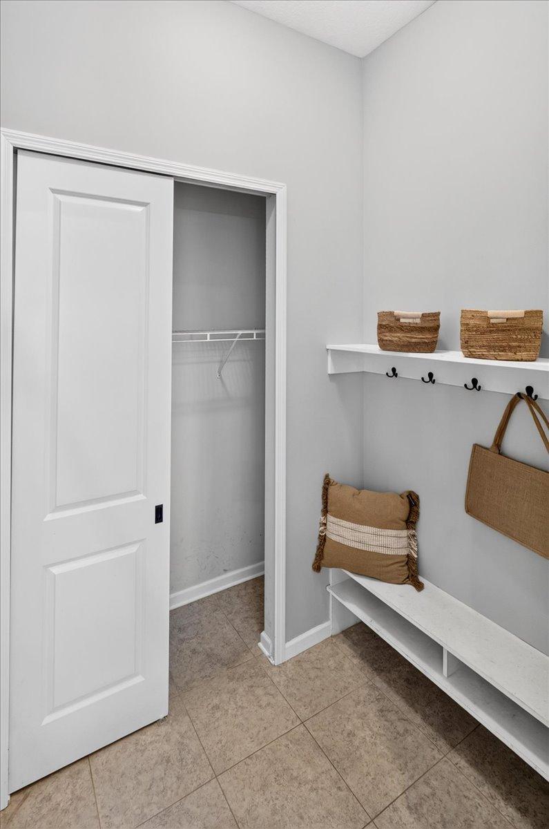 Convenient built-in bench, coat hooks, and closet storage provide an organized space for everyday essentials.