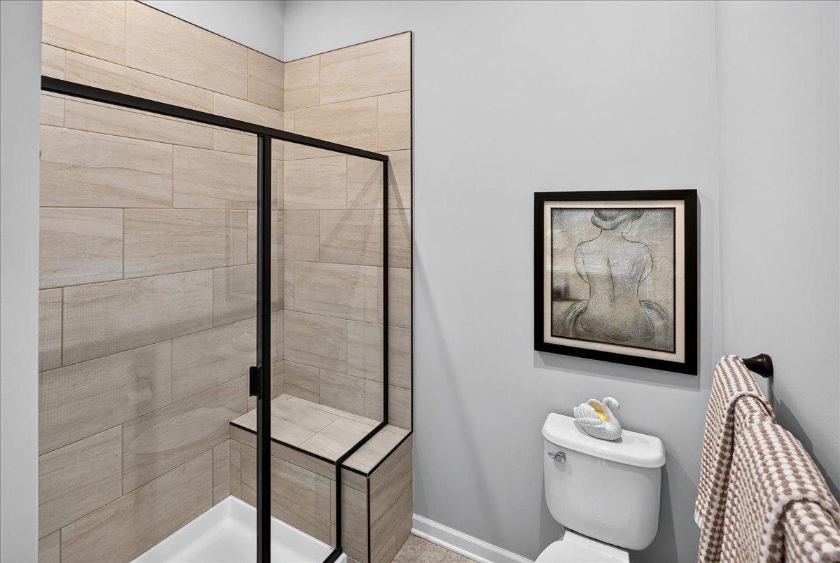 Beautifully tiled shower with glass enclosure, built-in bench, and modern finishes.