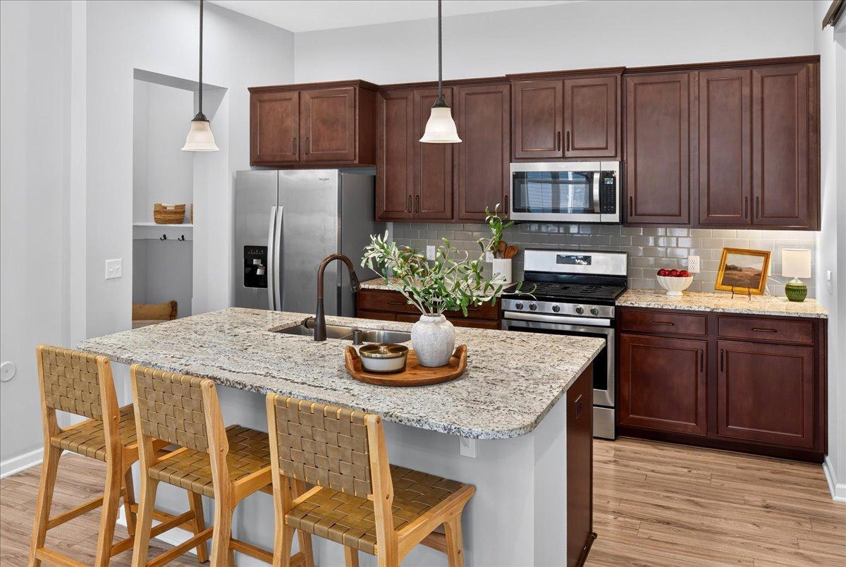 Beautiful cabinetry, granite countertops, stainless steel appliances, tile backsplash, and a generous center island with seating