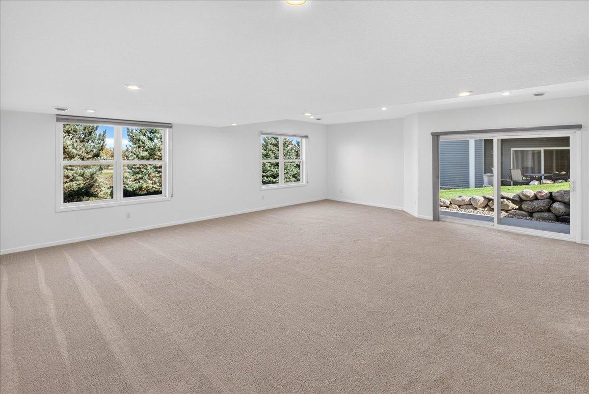 Large windows and a walkout patio door brighten the lower-level family room, creating an inviting extension of the home.
