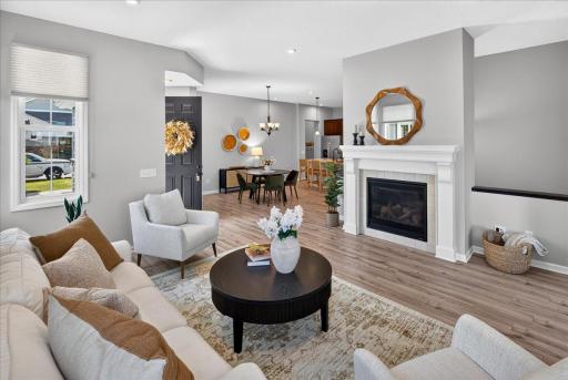 Open and inviting living area featuring a beautiful gas fireplace, abundant natural light, and a seamless connection to the dining area.