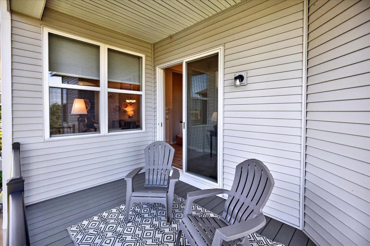 Extend your living space outdoors on the covered deck, offering a comfortable spot to relax while enjoying the surrounding green space.