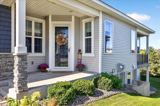 Inviting Front Entry. A welcoming covered front porch with attractive stone accents and beautifully maintained landscaping.