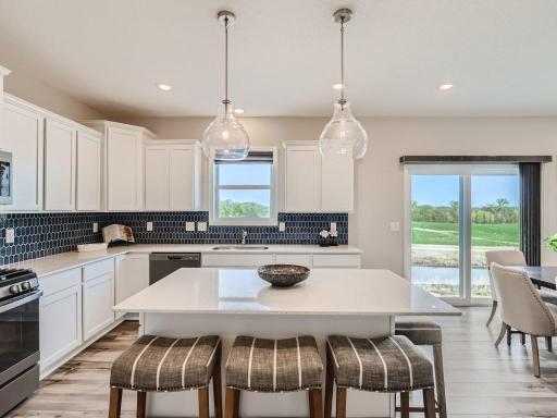 Photo is of the actual home. Timeless white cabinetry with and elegant backsplash.