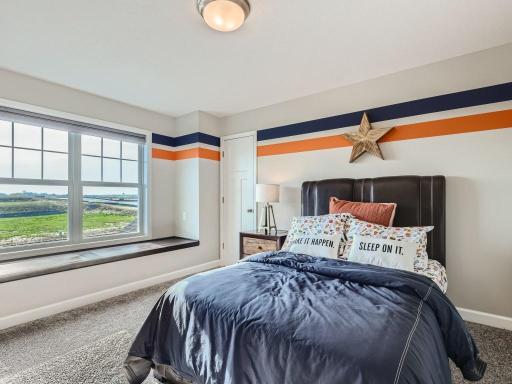 Photo is of the actual home. Upper level secondary bedrooms all with walk-in closets and this one even has a window seat.