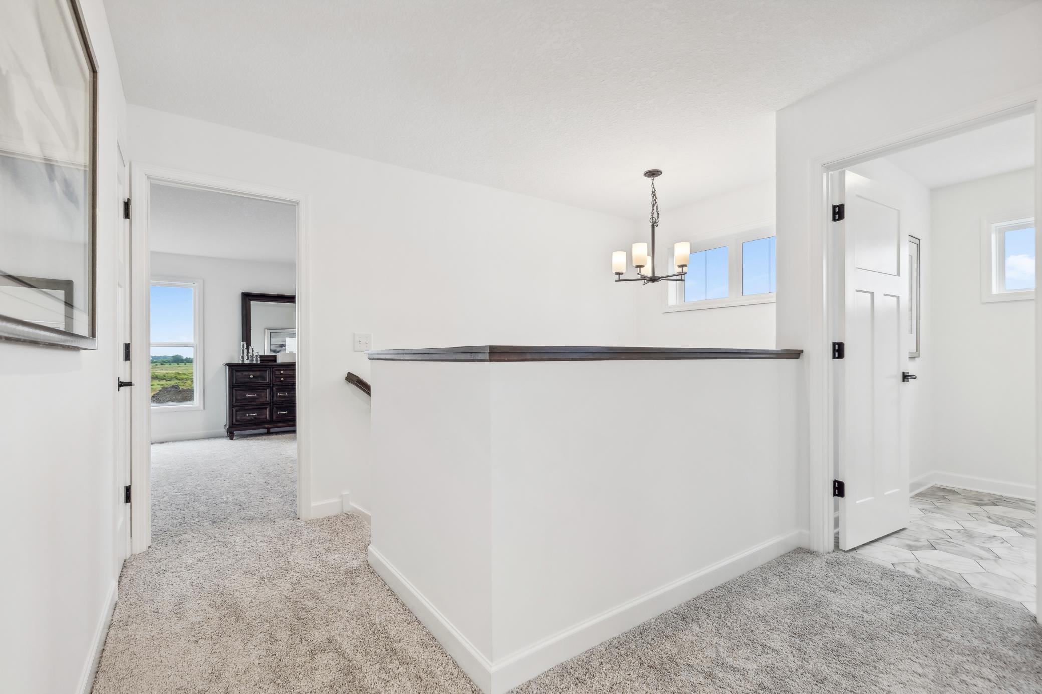 Thoughtfully designed upper-level landing offering a welcoming transition between bedrooms and providing valuable flexible space. *Photo of Actual Home