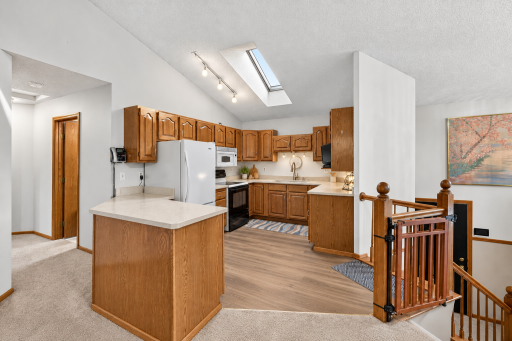 Skylight in the kitchen brings in so much natural light! Flooring & counters ai enhanced to show up a little update could do.
