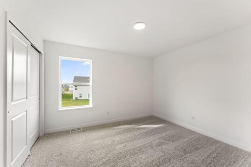 Two secondary bedrooms are located in a rear corner of the home, providing peaceful havens.