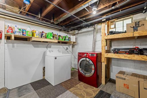 Convenient laundry area complete with shelving and a utility sink.