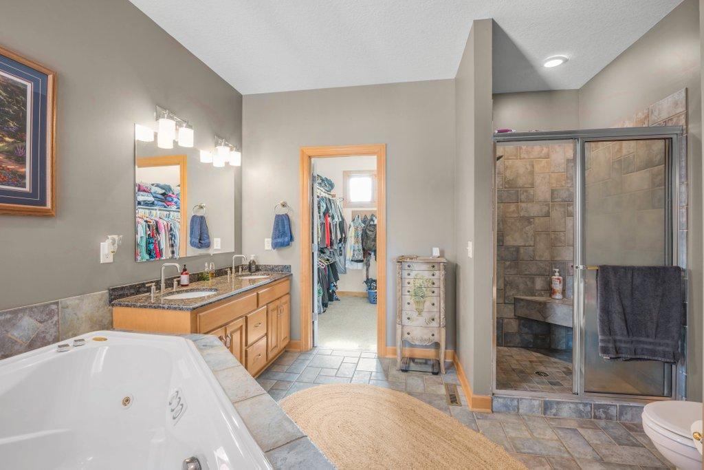 Private primary full bathroom with walk-in shower, double vanities, soaker tub, and walk-in closet.