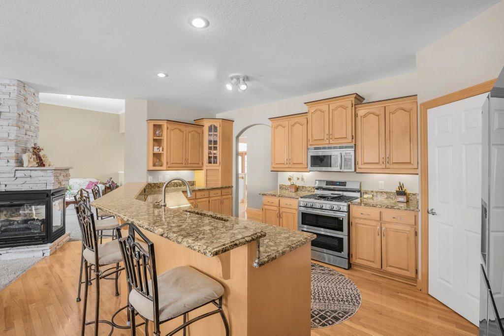Kitchen has a huge breakfast bar, granite countertops, high-end stainless appliances, and corner panty.