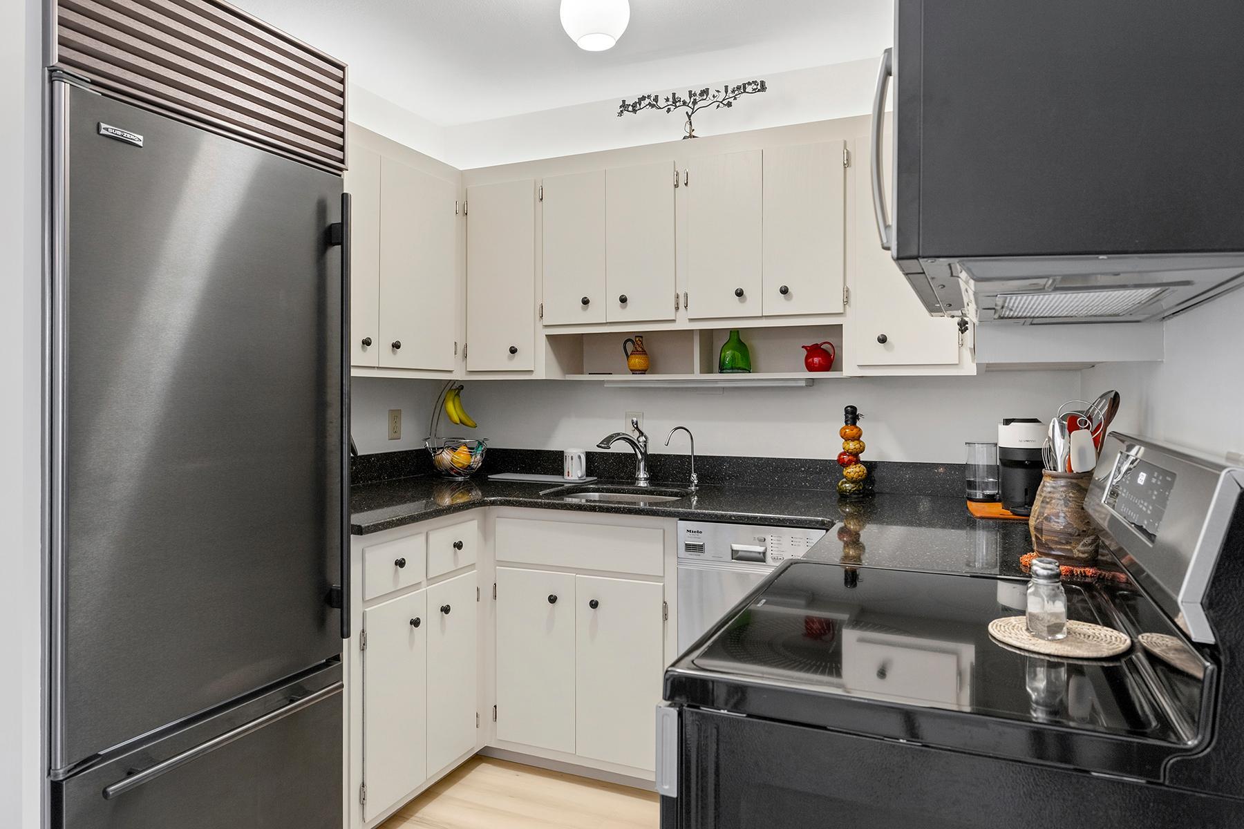 Neat and tidy kitchen with Sub-zero fridge, induction stove, and smart use of space.