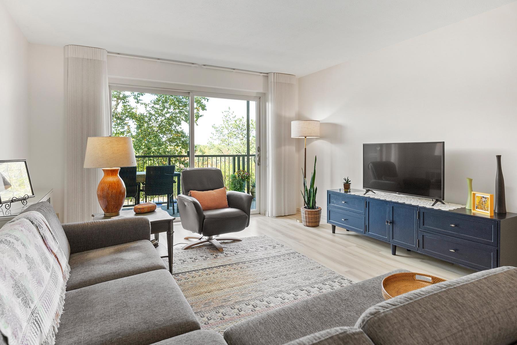 Living room with sliding glass doors facing west over the Mississippi River and extending to oversized balcony (22 x 6 ft).