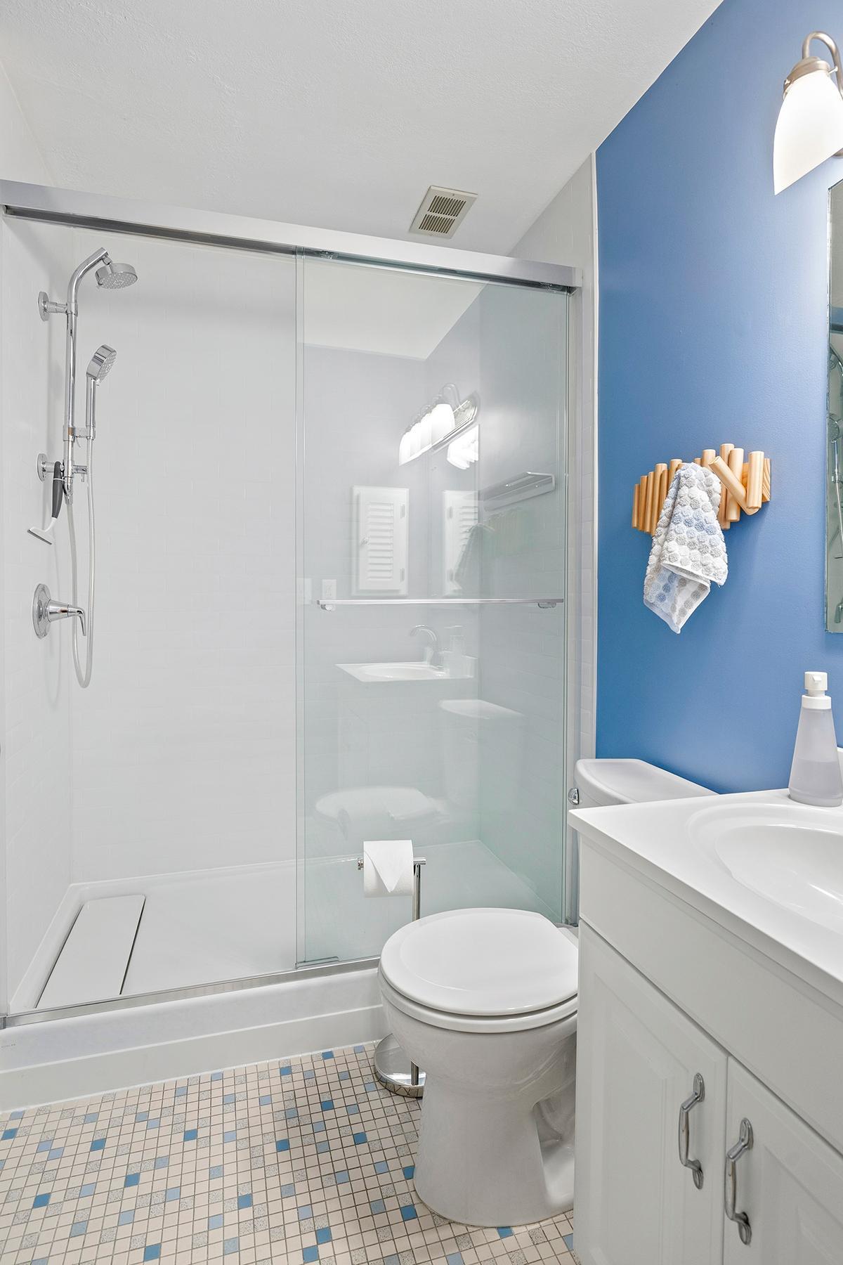 Bright and fresh bathroom with new shower (2026), mid-century tile and updated vanity.