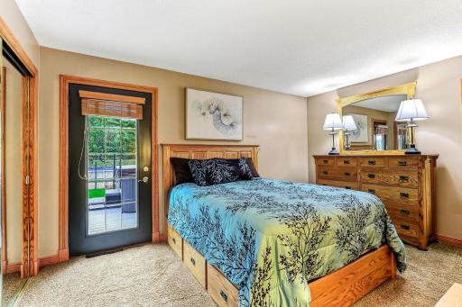 Main floor primary bedroom with walkout to deck and hot tub, plus a walk through bath attached.