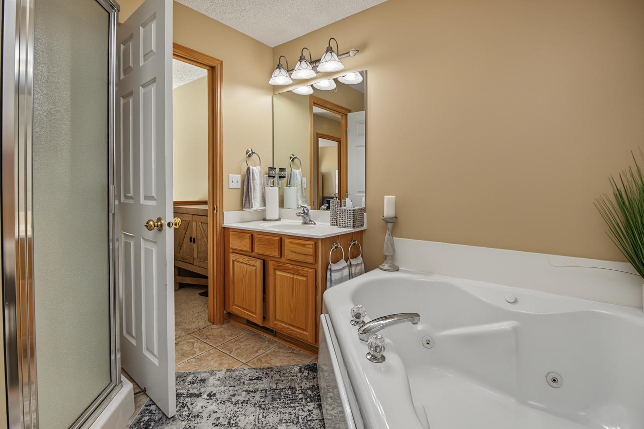 Walk-thru bath includes separate shower and jetted tub.