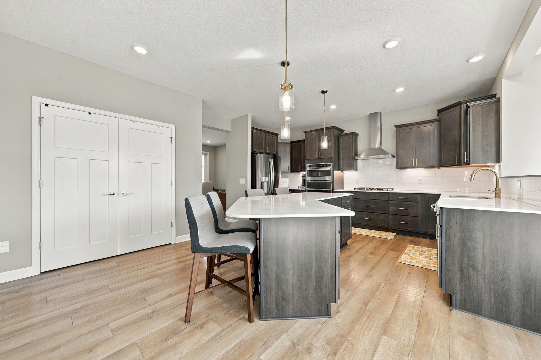 The gourmet kitchen features a large center island, hood vent, and panty.