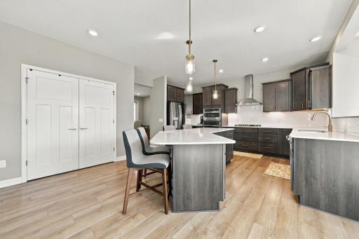 The gourmet kitchen features a large center island, hood vent, and panty.