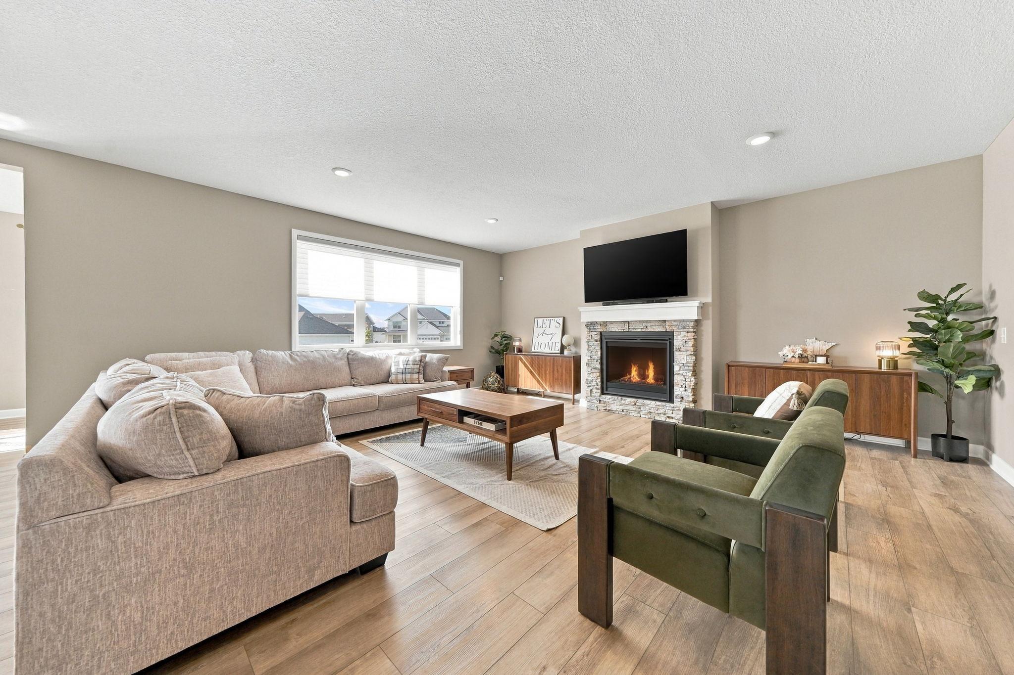 The spacious living room is complete with a gas burning stone fireplace.