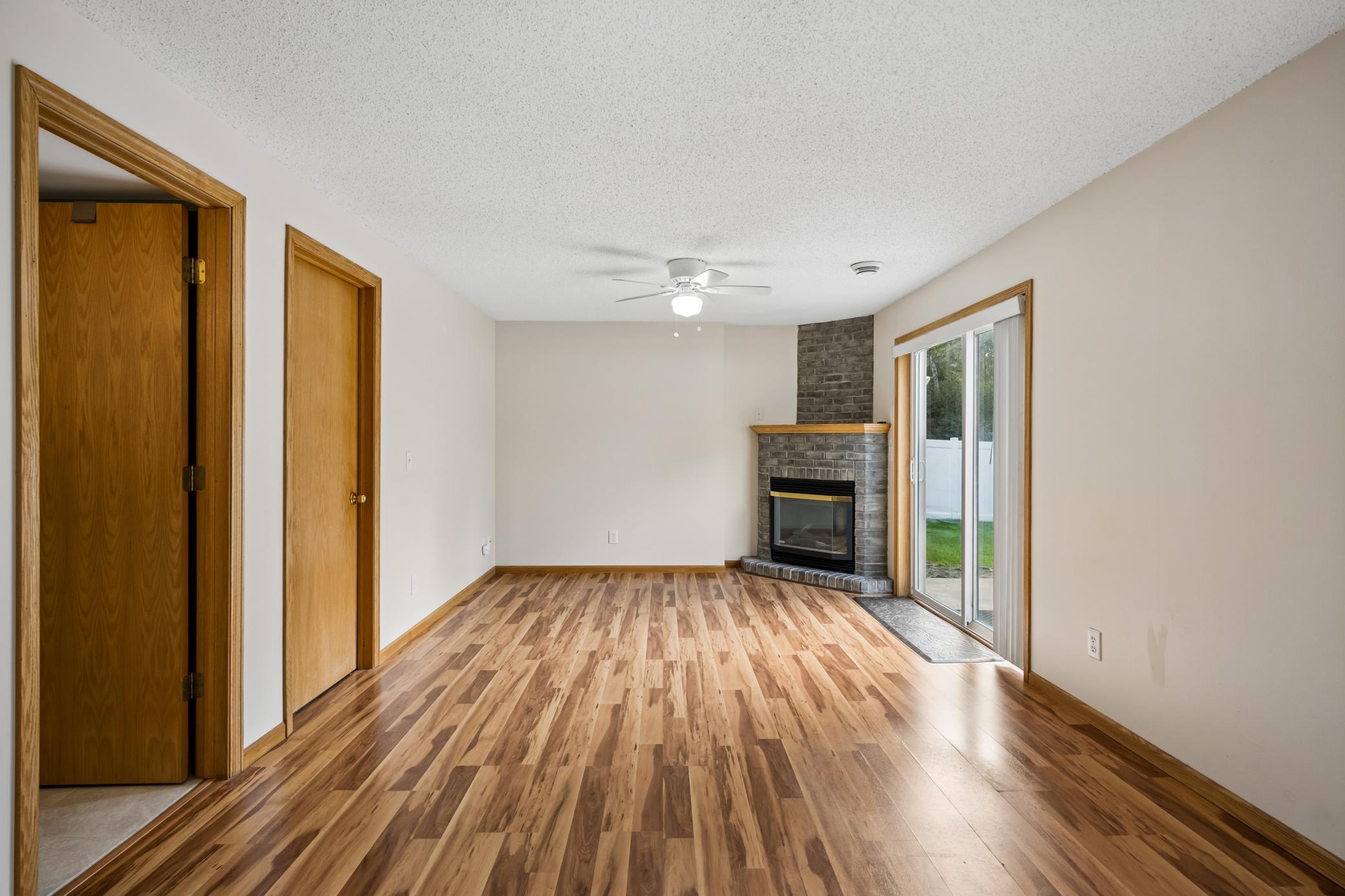 Hardwood floor in lower level family room with gas fireplace.