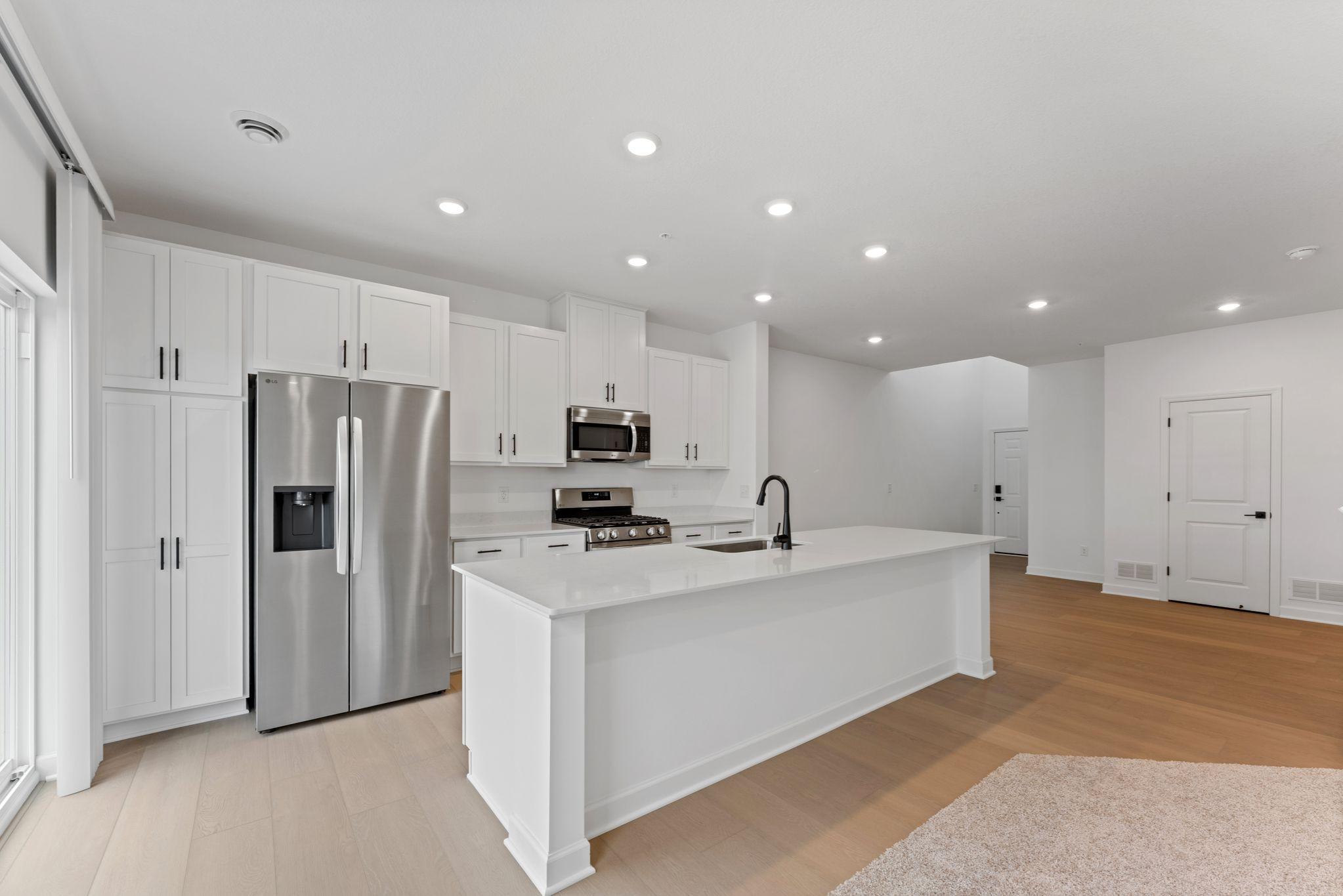 (Photo of a similar home, actual finishes may vary) At the focal point of this modern kitchen is a quartz-topped center island to add bar-style seating, and all-new stainless steel appliances to craft delicious meals.