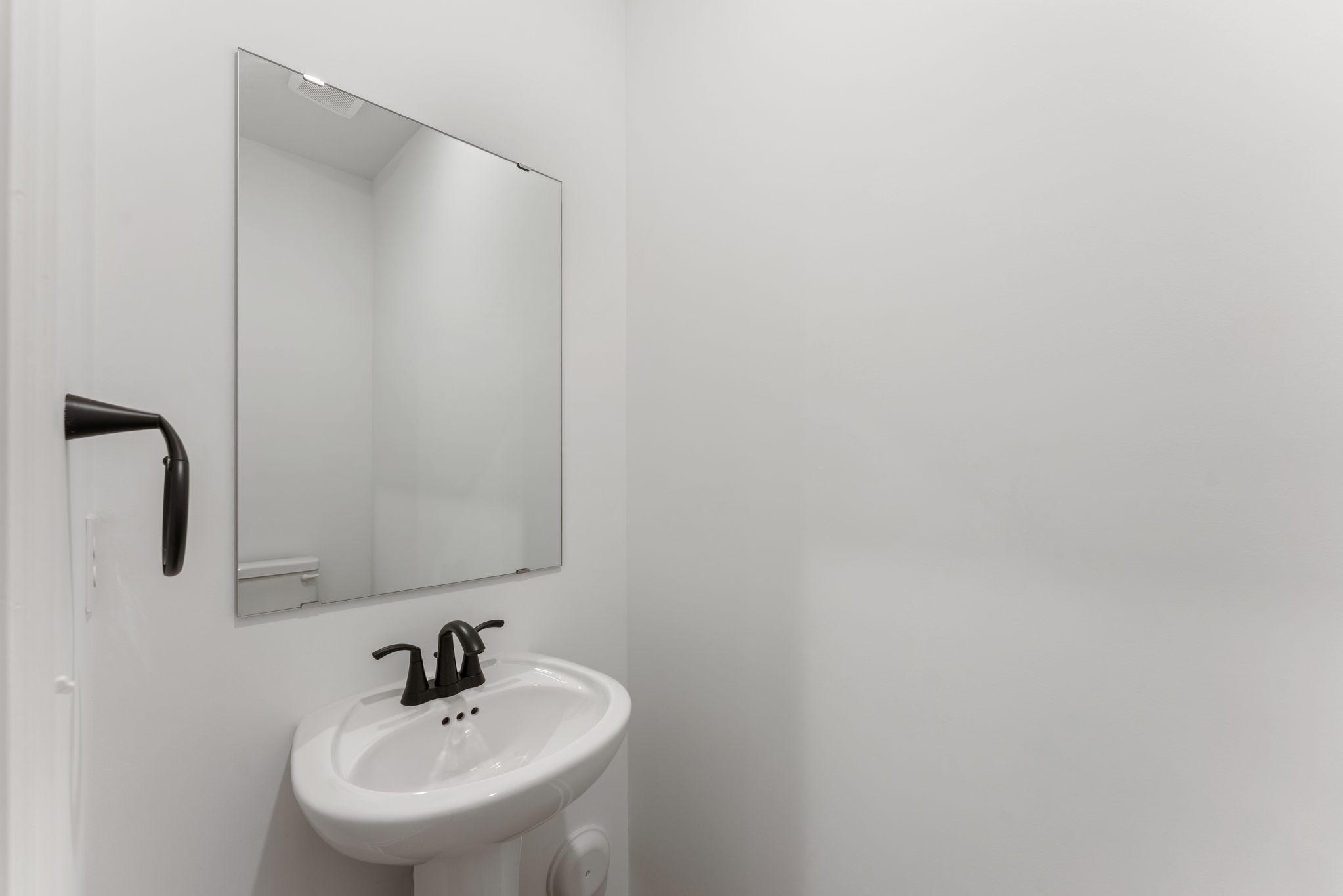 (Photo of a similar home, actual finishes may vary) In a discreet location on the first floor is a convenient powder room to accommodate the needs of the whole household and visiting guests.