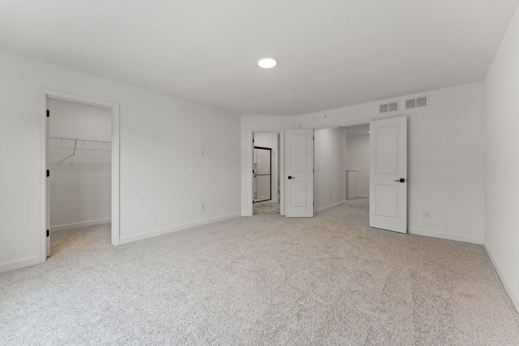 (Photo of a similar home, actual finishes may vary) The primary bedroom embraces natural light streaming in from the large windows