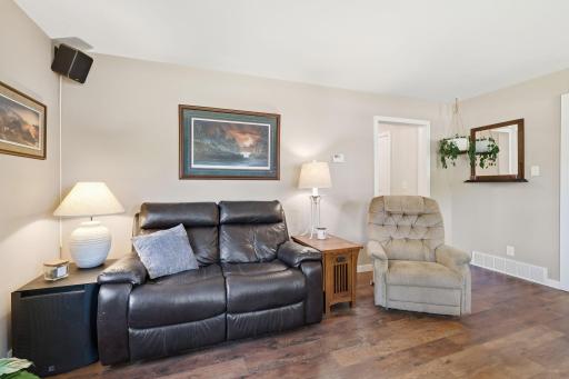 Inviting living room featuring warm wood-look flooring and a soft, neutral paletteâan ideal space to relax or gather with guests.