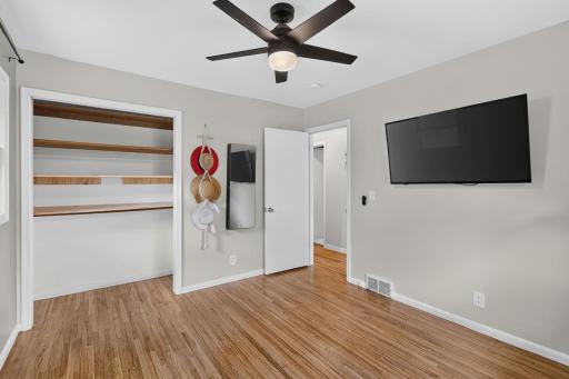 Comfortable main-level bedroom filled with natural light and beautiful hardwood floors.