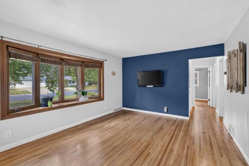 Bright living room with just-refinished hardwood floors and large bay window.