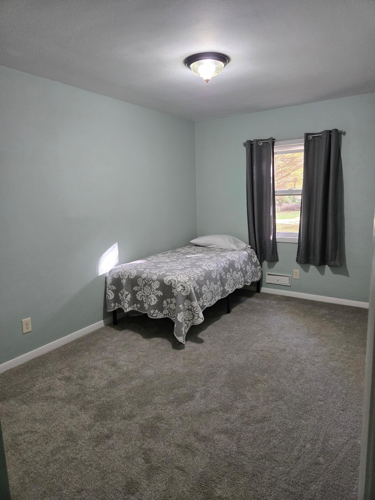 Bright and inviting main-level bedroom offering generous floor space and flexibility for a variety of furniture arrangements.
