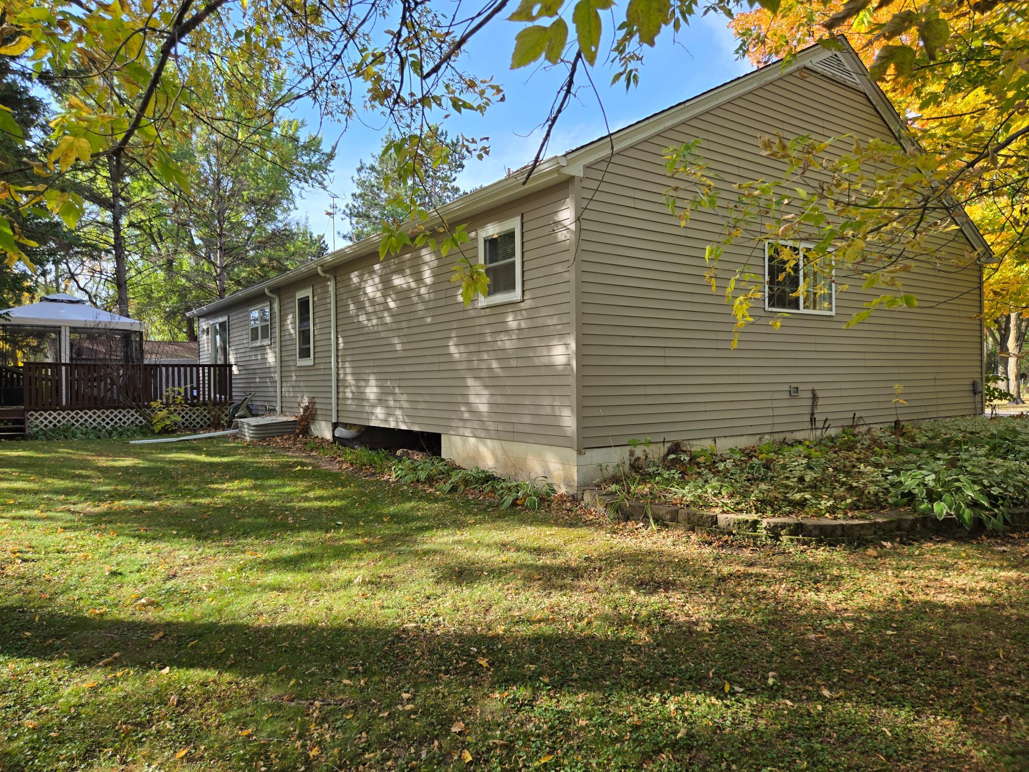 Enjoy the peaceful, tree-lined setting with a spacious lawn, established landscaping, and a deck overlooking the yard—perfect for outdoor relaxation and entertaining.