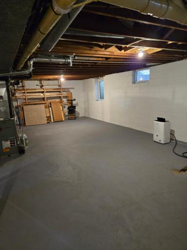 Additional view of the expansive unfinished lower level, featuring plenty of workspace and room for storage or recreational equipment.
