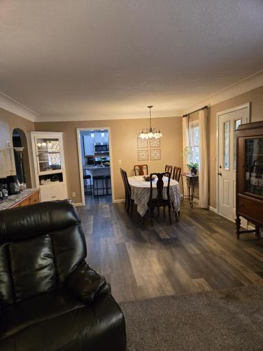 Comfortable dining space with beautiful flooring, a decorative light fixture, and a built-in corner cabinet for additional storage and display.
