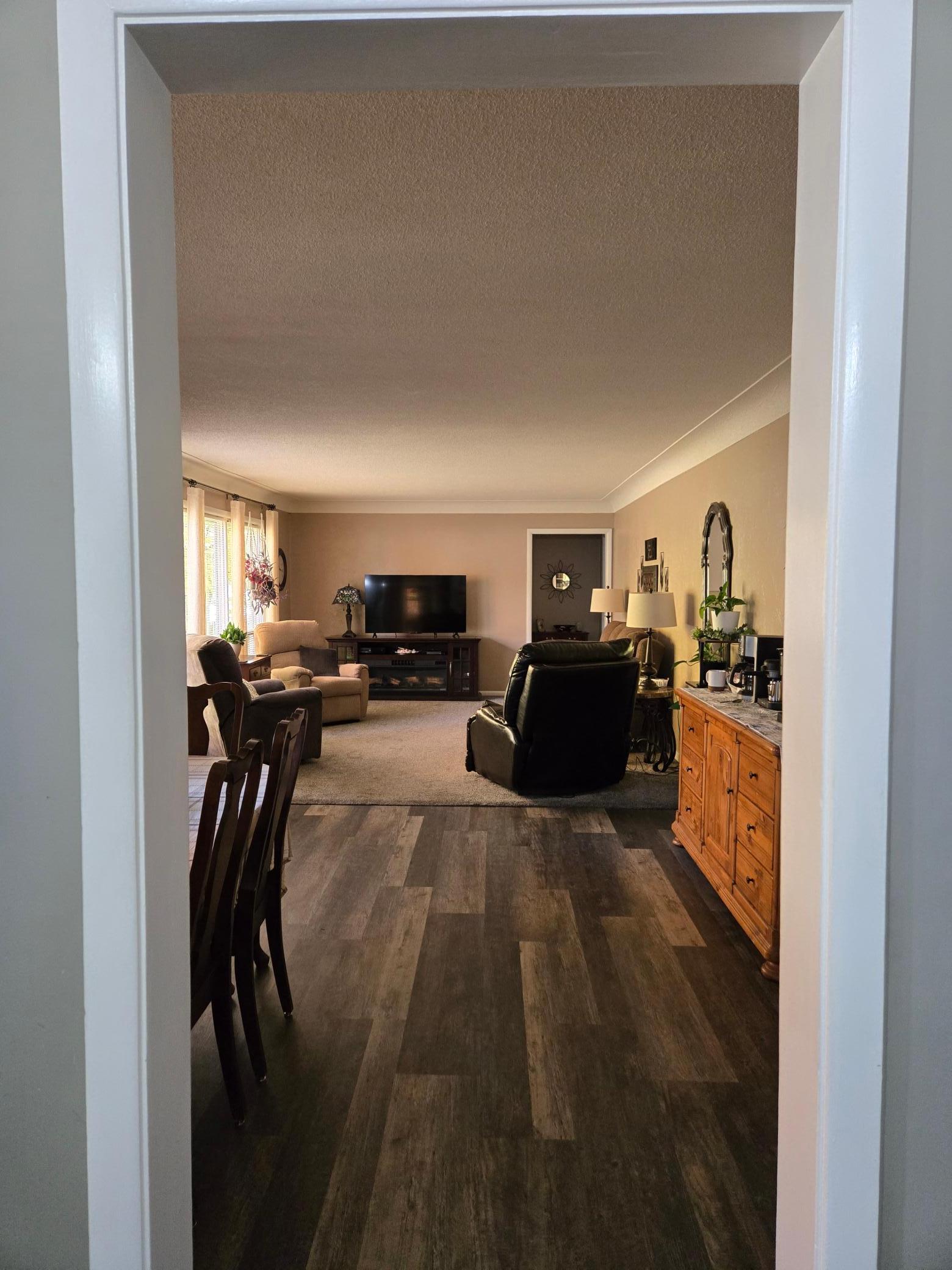 Welcoming view into the spacious main-level living room and adjoining dining area, featuring attractive flooring and a comfortable, inviting layout.