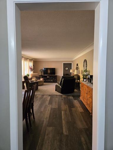 Welcoming view into the spacious main-level living room and adjoining dining area, featuring attractive flooring and a comfortable, inviting layout.