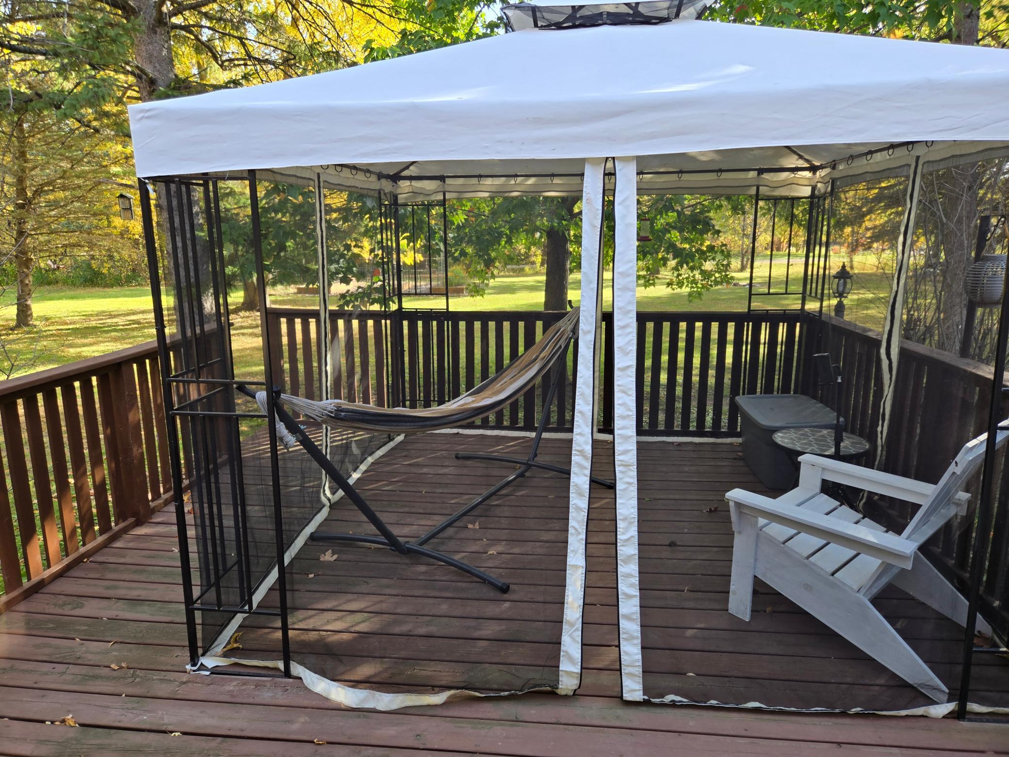 Spacious deck offering an inviting outdoor retreat for relaxing, entertaining, and enjoying peaceful views of the beautifully landscaped yard and mature trees.