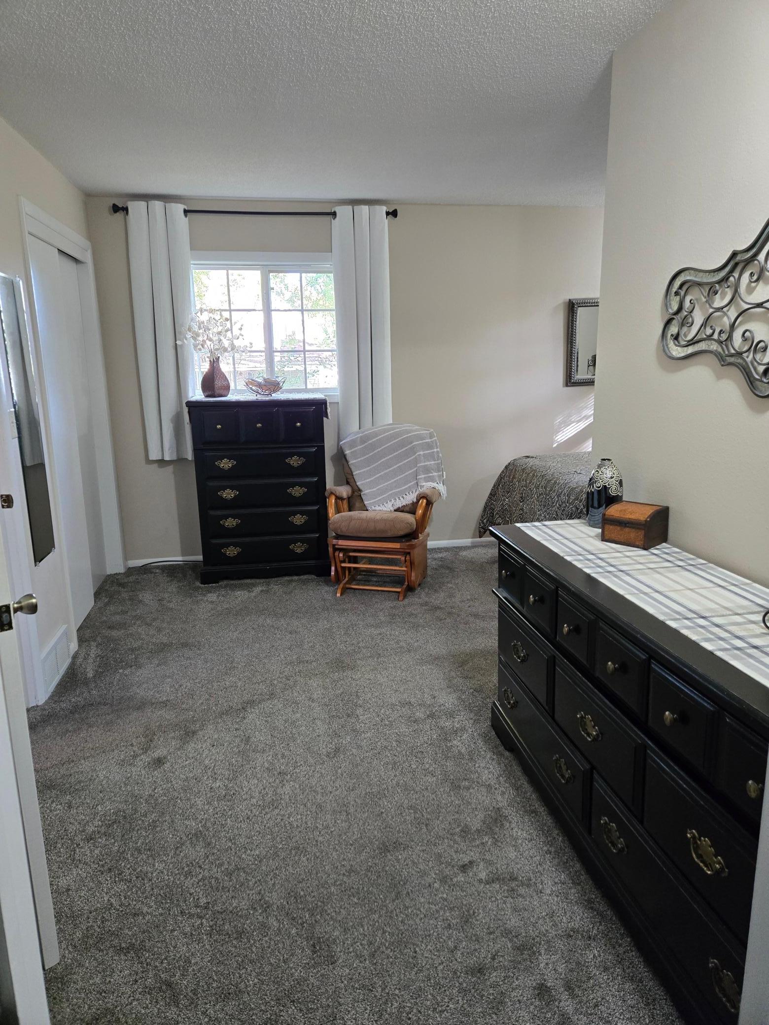 Additional view of the primary bedroom highlighting the generous floor space, natural light, and flexibility for bedroom furnishings.