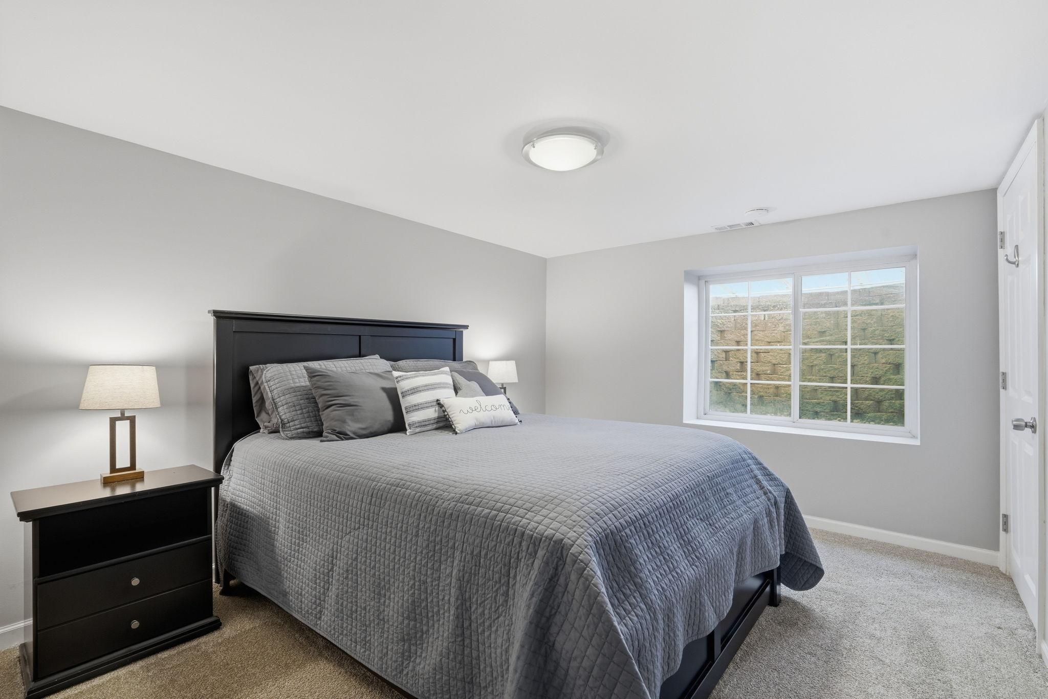 Lower-level bedroom offers calming neutral paint and lush carpet