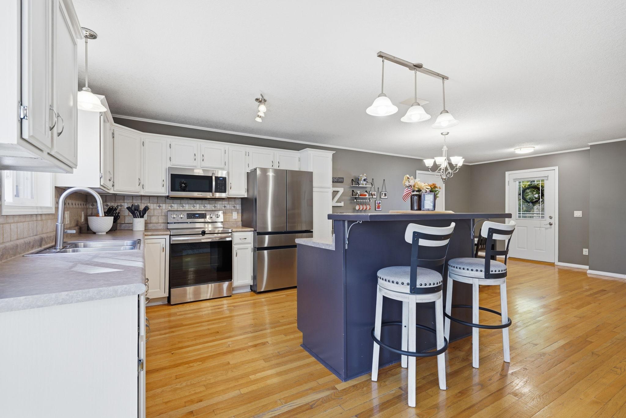 Center island offers breakfast bar seating, updated lighting, and added work space