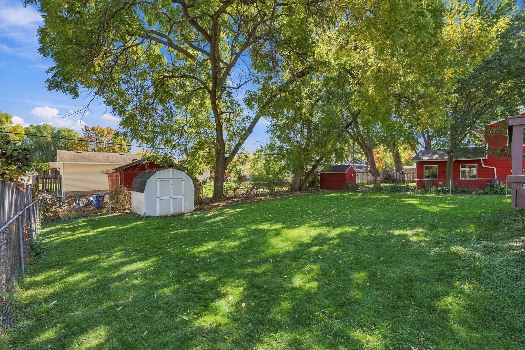 THIS backyard!! Fenced in for added relaxation, lush green lawn, mature trees provide excellent shade in the warm months, and storage shed too!