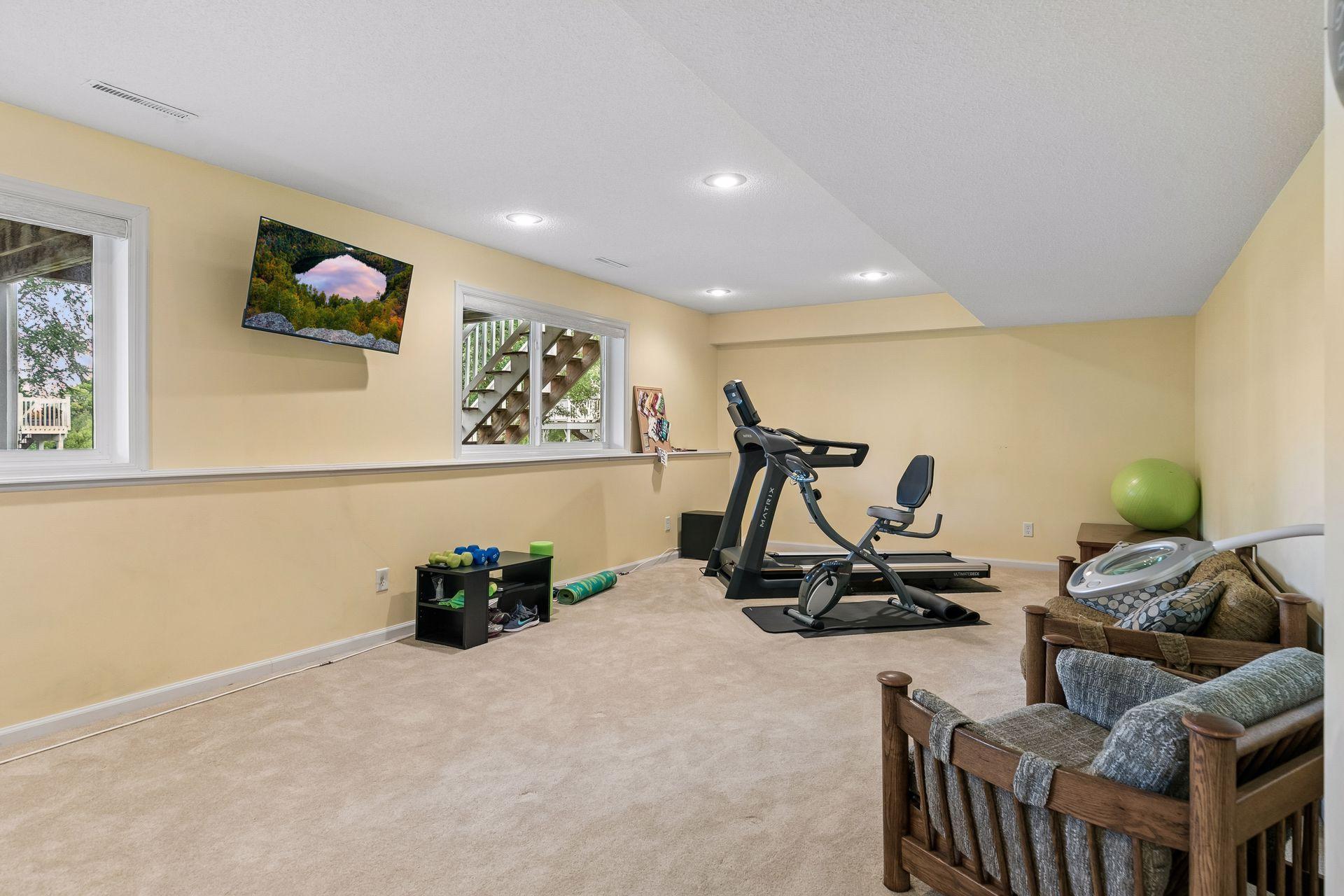 The generous lower level recreation room provides plenty of space to gather, exercise or entertain, with four garden level windows, carpet flooring, and recessed lighting.