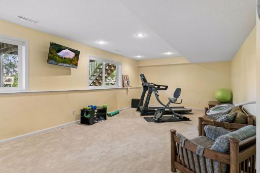 The generous lower level recreation room provides plenty of space to gather, exercise or entertain, with four garden level windows, carpet flooring, and recessed lighting.